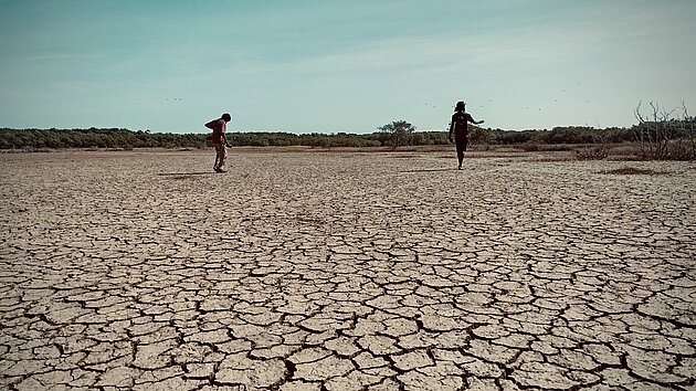 Photo of arrid landscape Northern Australia with two members of a Wik-Mungkan community in the distance.